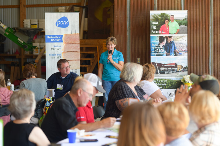 Joyce Hoppes with the Iowa Pork Producers Association shares about the We Care initiative and basic pork cooking guidelines during the lunch on Jonathan Wetter’s pork farm. Photo credit: Joseph L. Murphy/Iowa Soybean Association