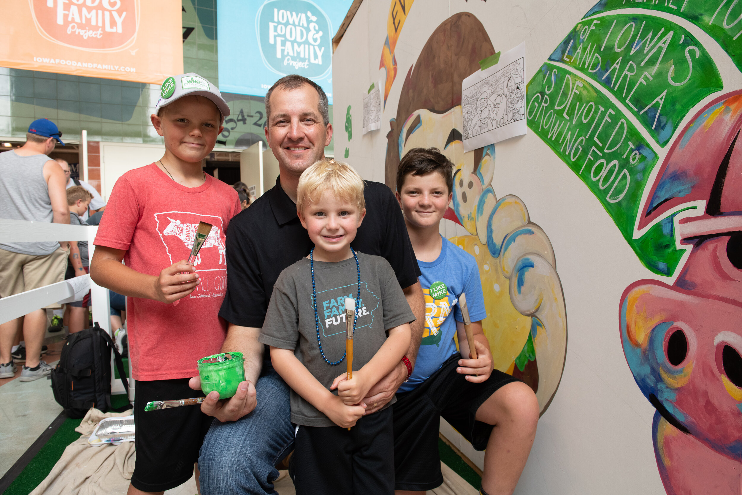 The 2018 display included a mural that was painted during the course of the fair. Pictured is Iowa Secretary of Agriculture Mike Naig and his family who jumped in as guest painters.